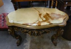 A CARVED WOOD, SHAPED OVAL COFFEE TABLE, WITH INLET ONYX TOP