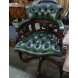 A CAPTAIN?S CHAIR, BUTTON UPHOLSTERED IN GREEN HIDE, REVOLVING ON A MAHOGANY FIVE SPUR BASE