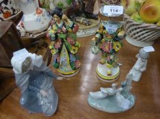 A PAIR OF ITALIAN POTTERY MALE AND FEMALE FIGURES, IN ELABORATE FLORAL COSTUMES, ON CIRCULAR