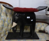 AN AFRICAN EARLY TWENTIETH CENTURY CARVED AND EBONISED WOOD ELEPHANT STOOL WITH HOLLOWED PANEL SEAT,
