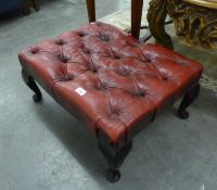 AN OBLONG STOOL, BUTTON UPHOLSTERED IN CRIMSON HIDE ON CABRIOLE LEGS