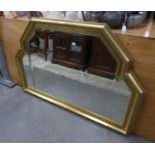 A MODERN ORNAMENTAL MIRROR WITH BEVELLED GLASS, IN GILT CAVETTO FRAME WITH STEPPED TOP