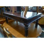 AN OBLONG SOLID DARKWOOD COFFEE TABLE (110cm x 60cm), WITH METAL BANDING TO CORNERS AND A DEMI-