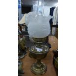 A BRASS OIL TABLE LAMP WITH FROSTED GLASS SHADE WITH FRILL TOP AND GLASS FUNNEL; ANOTHER WITH