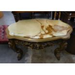 A CARVED WOOD, SHAPED OVAL COFFEE TABLE, WITH INLET ONYX TOP
