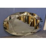 AN OVAL BEVELLED EDGE LARGE WALL MIRROR, WITH BROAD FACETED MIRROR GLASS BORDER
