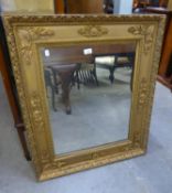 AN OBLONG WALL MIRROR, IN ORNATE CARVED WOOD GILT FRAME (89cm x 77cm)