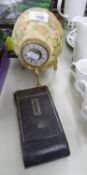 A DECORATED OSTRICH EGG WITH FITTED CLOCK ON STAND AND AN OLD POCKET CAMERA (2)