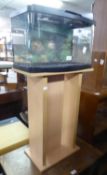 A FISH TANK, ON MODERN BLOND WOOD STAND