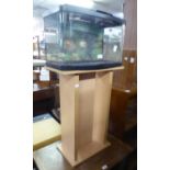 A FISH TANK, ON MODERN BLOND WOOD STAND