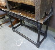 A LATE 19TH CENTURY CARVED DARK OAK SIDE TABLE, WITH LEDGE BACK, END DRAWER, CARVED APRON, ON TURNED