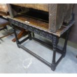 A LATE 19TH CENTURY CARVED DARK OAK SIDE TABLE, WITH LEDGE BACK, END DRAWER, CARVED APRON, ON TURNED