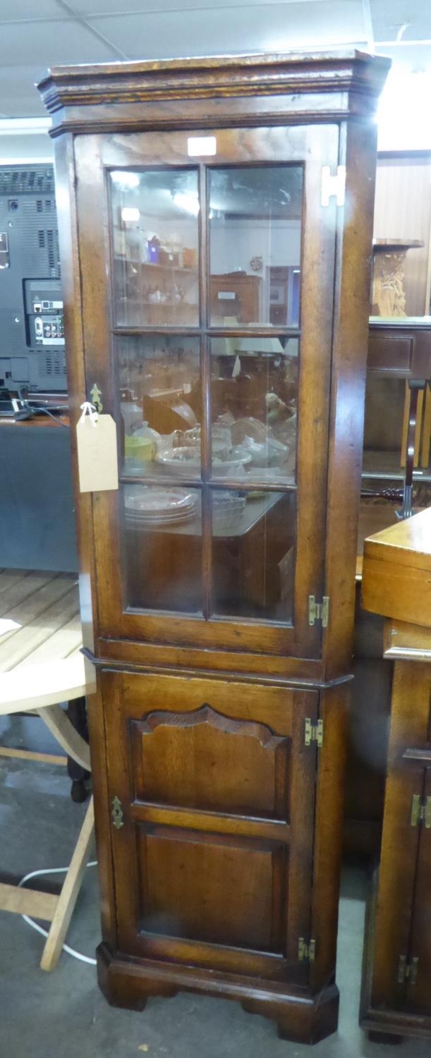18TH CENTURY STYLE OAK SMALL DOUBLE CORNER CUPBOARD, WITH GLAZED PANE PANEL DOOR OVER A FRAMED PANEL