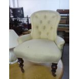 AN ANTIQUE BUTTON BACK NURSING CHAIR, COVERED IN CREAM FABRIC, RAISED ON TURNED FRONT SUPPORTS