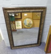 A RECTANGULAR BEVELLED EDGE WALL MIRROR IN CARVED OAK FRAME