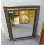 A RECTANGULAR BEVELLED EDGE WALL MIRROR IN CARVED OAK FRAME