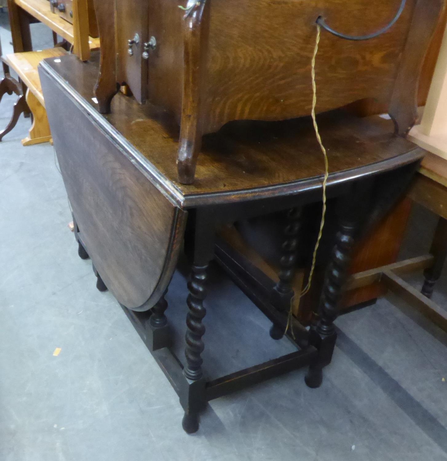 AN OAK OVAL GATE LEG DINING TABLE, ON SPIRALLY TWISTED SUPPORTS