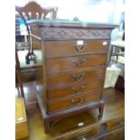 A MAHOGANY MUSIC CABINET, WITH BLIND FRET CARVED FRIEZE AND FIVE FALL FRONT DRAWERS