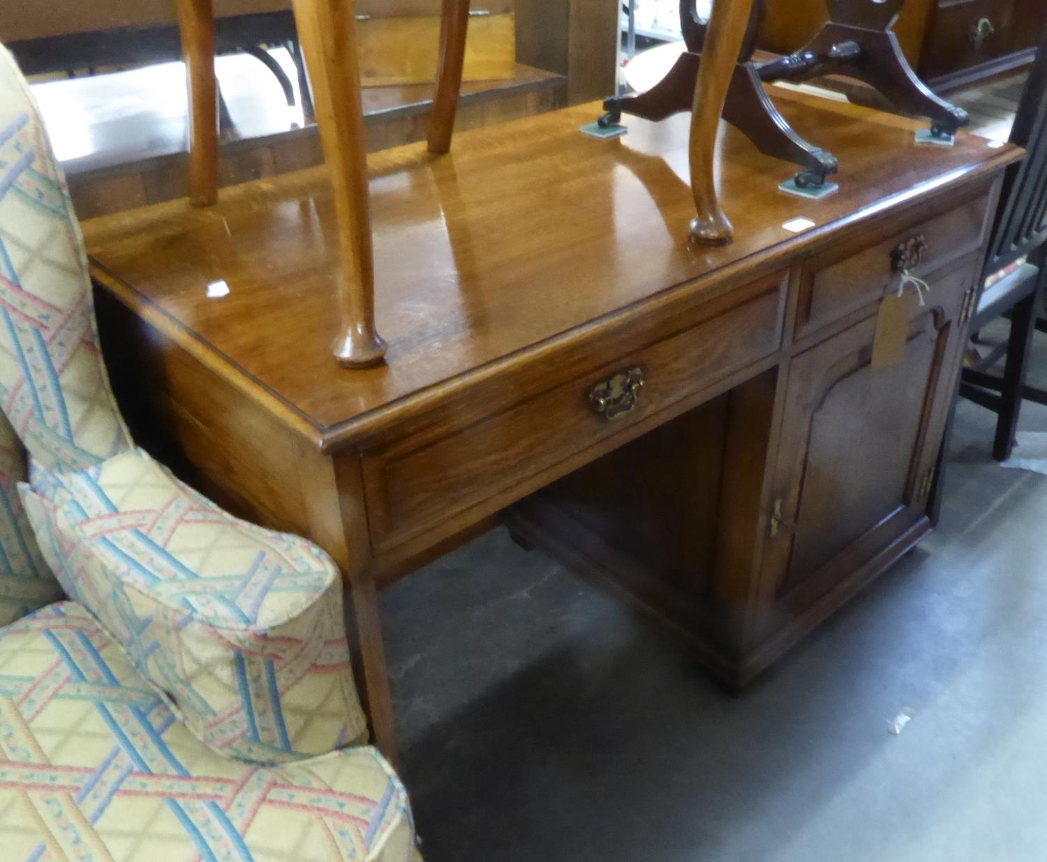 AN OAK SINGLE PEDESTAL DESK WITH TWO FRIEZE DRAWERS AND A SINGLE PEDESTAL CUPBOARD WITH COFFERED