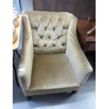 AN EDWARDIAN EASY ARMCHAIR, OF SQUARE FORM WITH BUTTON BACK, COVERED IN GOLD COLOURED FABRIC AND