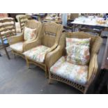 A SET OF THREE BAMBOO AND CANE CONSERVATORY ARMCHAIRS WITH LOOSE CUSHIONS