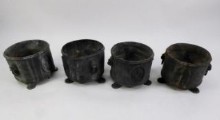 SET OF FOUR HEAVY LEAD JARDINIÈRES, cylindrical with embossed simulated mask head and ring handles