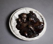 BRONZE EFFECT RELIEF OF TWO CHILDREN, applied to a circular black and white variegated marble