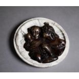 BRONZE EFFECT RELIEF OF TWO CHILDREN, applied to a circular black and white variegated marble
