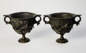 PAIR OF NINETEENTH CENTURY PATINATED BRONZE TWO HANDLED PEDESTAL VASES, each of typical, cast in