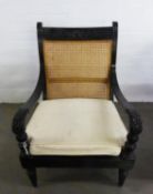 19th CENTURY ANGLO INDIAN EBONISED LIBRARY OPEN ARMCHAIR, the fluted shoulder board carved with