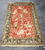 QUM, PERSIAN, PART-SILK HUNTING RUG, the red field decorated with seven Persian equestrian figures