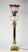 VICTORIAN BRASS CORINTHIAN COLUMN OIL TABLE LAMP, of fluted form with ruby tinted etched glass