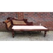 NINETEENTH CENTURY CARVED MAHOGANY AND CANED CHAISE LONGUE, of typical form with carved scroll end.