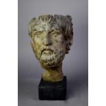 CAST METAL FACE MASK OF A ROMAN EMPEROR, after the classical original, on a black composition oblong