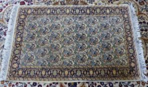 HERAT, PERSIAN RUG, WITH ALL-OVER REPEAT FLOWERING SHRUB AND PEAR PATTERN on an off-white field,