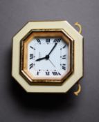 CARTIER, PARIS, GILT METAL AND CREAM ENAMELLED TRAVELLING ALARM CLOCK, the octagonal Roman dial,