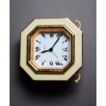 CARTIER, PARIS, GILT METAL AND CREAM ENAMELLED TRAVELLING ALARM CLOCK, the octagonal Roman dial,