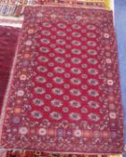 PAKISTAN BOKHARA LARGE RUG, with four rows of white, crimson and orange guls on a crimson field,