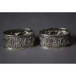 PAIR OF VICTORIAN SILVER OVAL NAPKIN RINGS, repoussé with flowers and scrolls, Birmingham 1897,