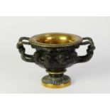 PATINATED AND GILT BRONZE MODEL OF AN ORNATE TWO HANDLED PEDESTAL VASE, SIMILAR TO THE WARWICK VASE,