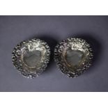 PAIR OF SILVER COLOURED METAL PIERCED AND REPOUSSÉ HEART SHAPED SWEET MEAT DISHES, each on three