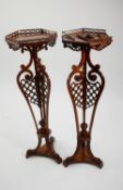 PAIR OF CHIPPENDALE STYLE FRET CARVED MAHOGANY TORCHÈRE STANDS with hexagonal gallery tops, three