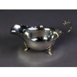 SILVER SAUCE BOAT, oval with cyma edge, free scroll handle with dragon?s head terminal, raised on