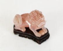 CHINESE, POSSIBLY REPUBLICAN PERIOD, ROSE PINK QUARTZITE CARVED MODEL OF A BUDDHISTIC LION, on