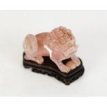 CHINESE, POSSIBLY REPUBLICAN PERIOD, ROSE PINK QUARTZITE CARVED MODEL OF A BUDDHISTIC LION, on