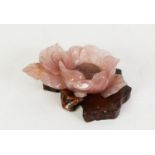 CHINESE, POSSIBLY REPUBLIC PERIOD CARVED ROSE PINK QUARTZITE PEONY with issuing leafage, on a root