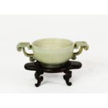 CHINESE QING DYNASTY CELADON JADE ARCHAISTIC BOWL with angular scroll handle, shallowly carved