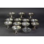 SET OF TWELVE SILVER SUNDAE DISHES, cut card pierced with shaped tops, single scroll handle, on stem