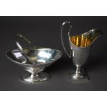 GEORGE III STYLE SILVER HELMET SHAPED CREAM JUG with raised handle, on circular socle and square