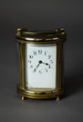 EARLY TWENTIETH CENTURY GILT POLISHED BRASS CASED OVAL CARRIAGE CLOCK, with top carrying handle